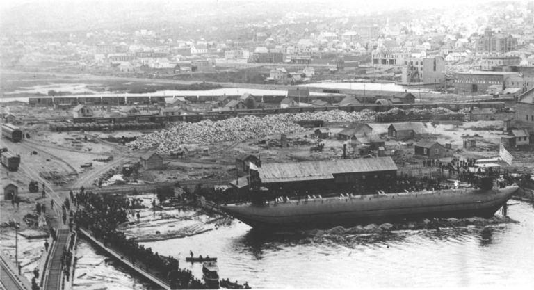 A black and white photo showing the boat yards in Duluth and crowds gathered to see the launch of a new whaleback ship.