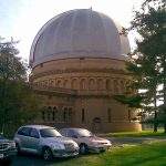 A color image showing the exterior of the Yerkes Observatory with cars in the foreground