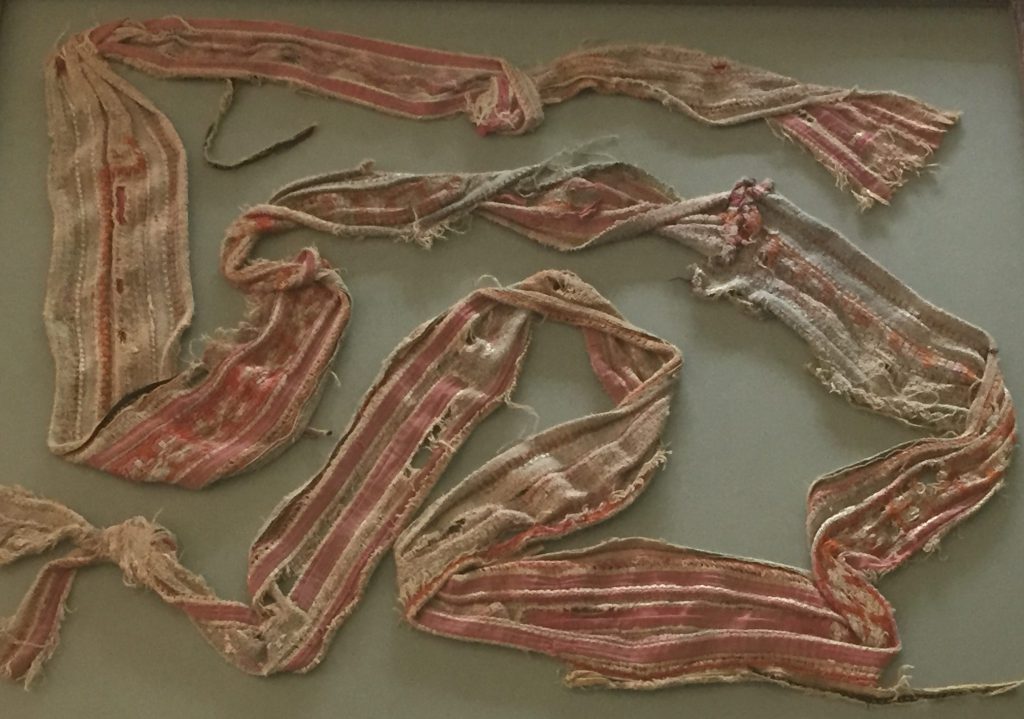 An image of a tattered embroidered baby sash
