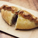 an image of a cut cornish pasty showing the filling and edging