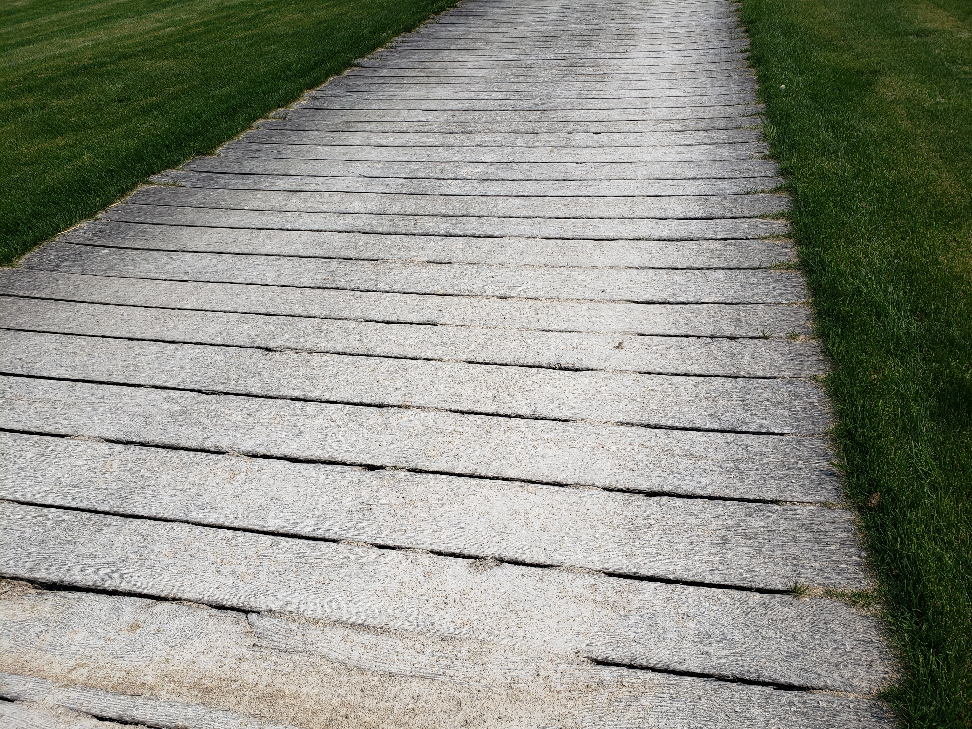 A plank road across a grass field