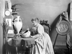 Photograph of Susan Frackleton painting a piece of porcelain